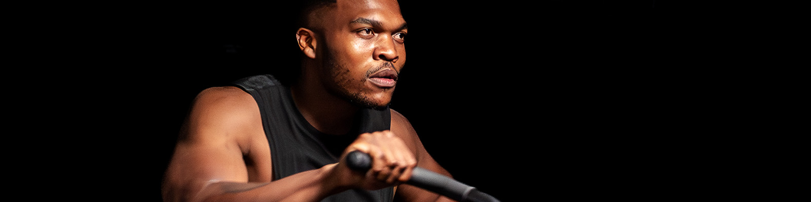 Man training in a Planet Fitness with a black background